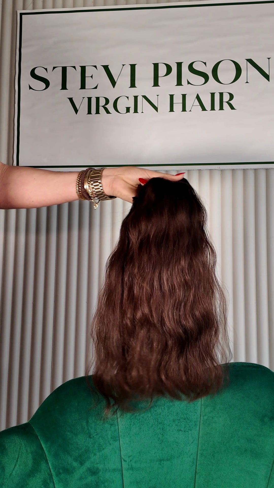 18 inch Russian single donor virgin hair tail in chocolate brown, held up against the Stevi Pisoni Virgin Hair backdrop