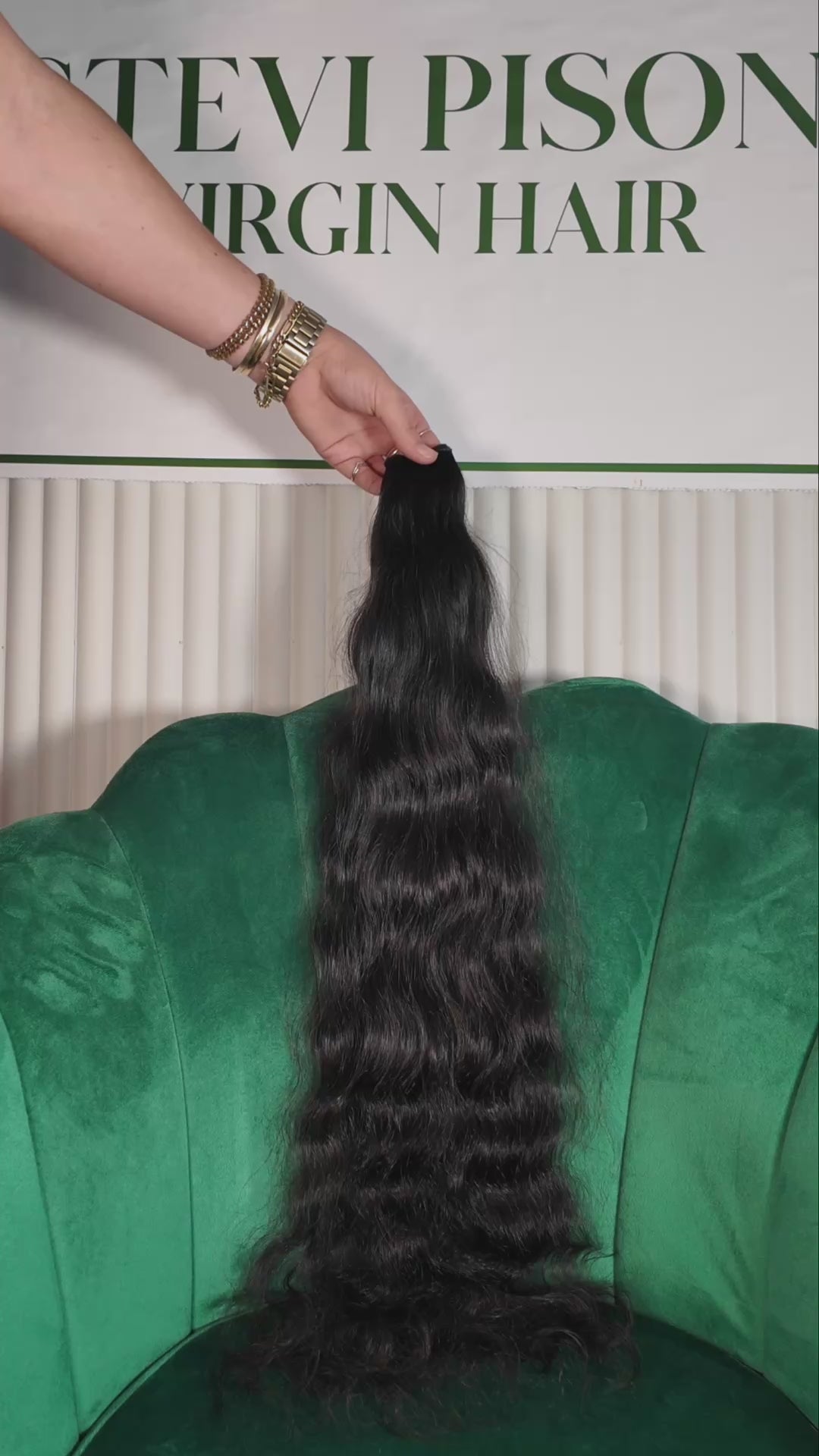 27 inch Russian single donor black virgin wavy hair tail held against the Stevi Pisoni Virgin Hair backdrop